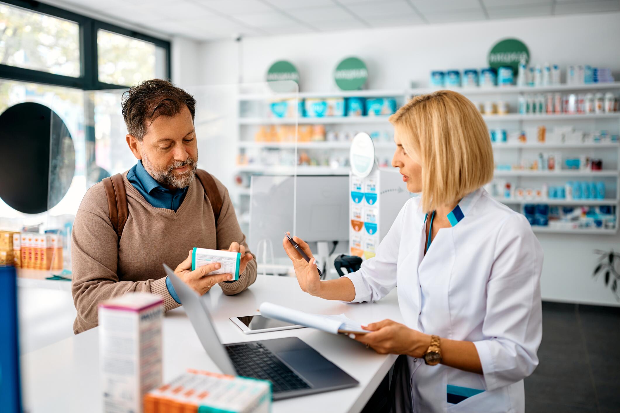 OG_MAN_TALKING_TO_THE_PHARMACIST_WHILE_BUYING_DRUGS_IN_THE_PHARMACY_ISTOCK_2023