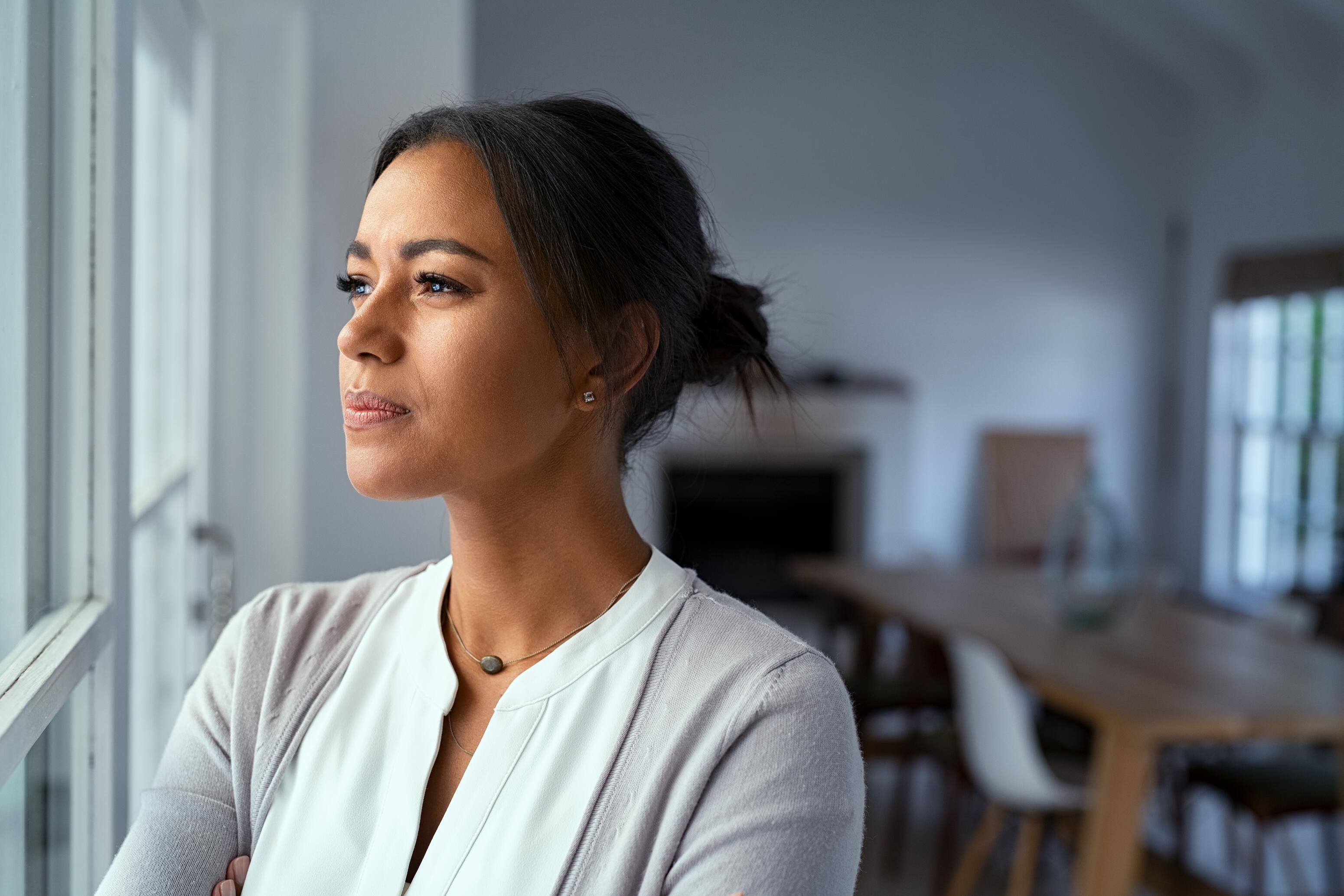 OG_WOMAN_LOOKING_WINDOW_THINKING_ISTOCK_2021