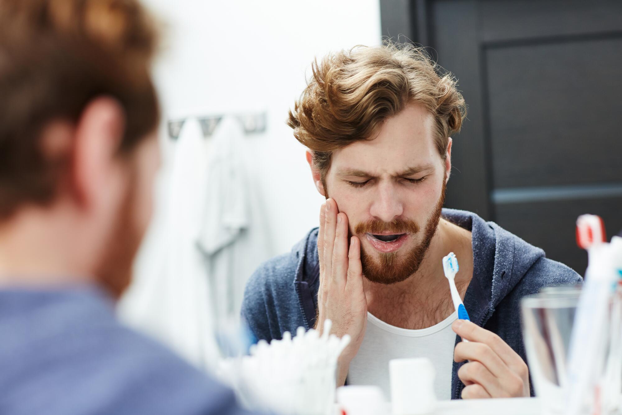 OC_YOUNG_MAN_TOOTHBRUSH-HURT_PAIN_BATHROOM_SHUTTERSTOCK_614668055