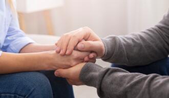 OG_MAN_HOLDING_HANDS_AND_REASSURING_A_WOMAN_ISTOCK_2022
