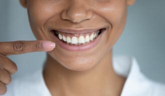 OG_FINGER_SHOWING_AFRICAN_WOMAN-S_HEAD_WITH_SMILE_AND_PERFECT_WHITE_TEETH_ISTOCK_2023