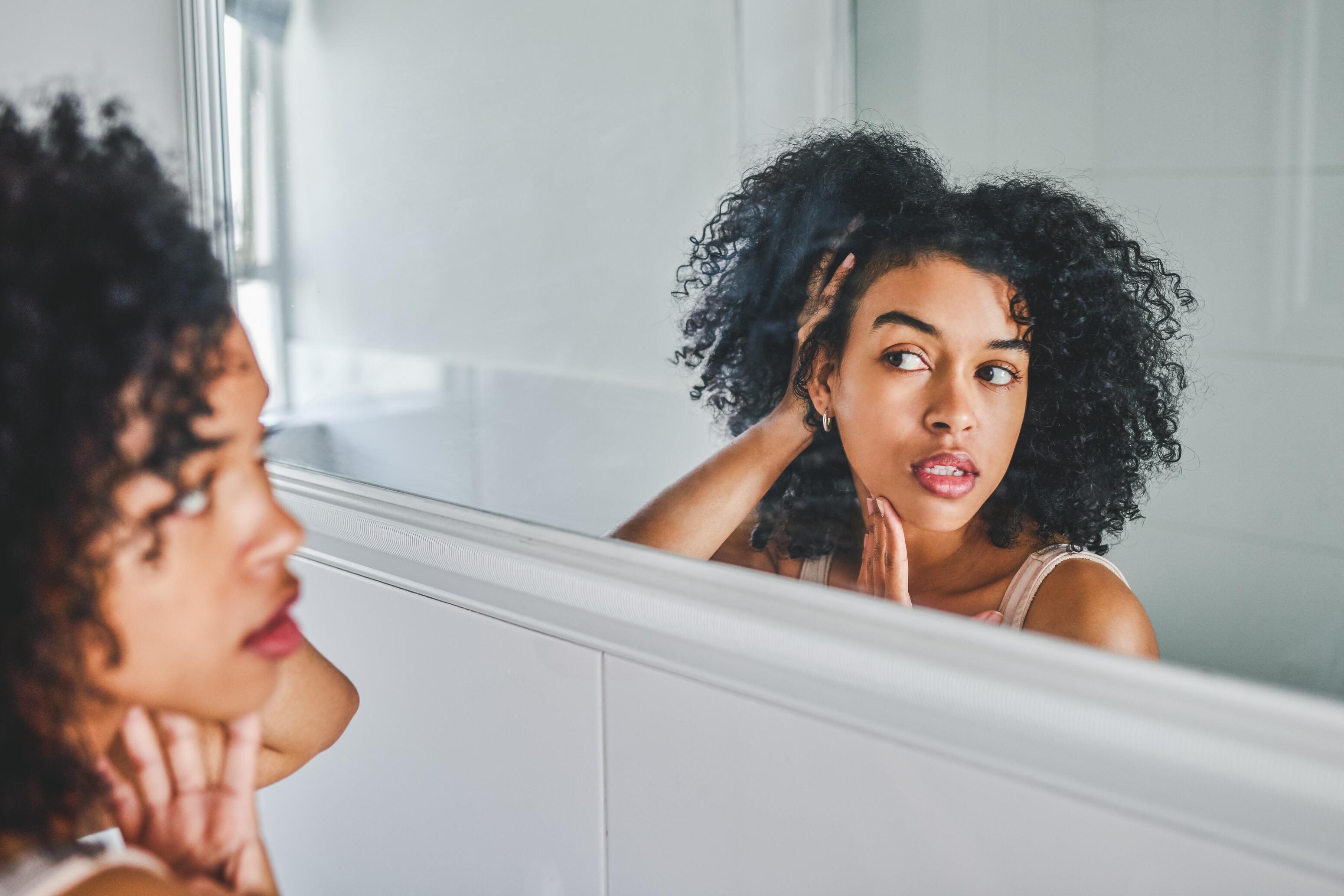 AD_ACNE-YOUNG-WOMAN-LOOKING-IN-MIRROR_LARGE_2021