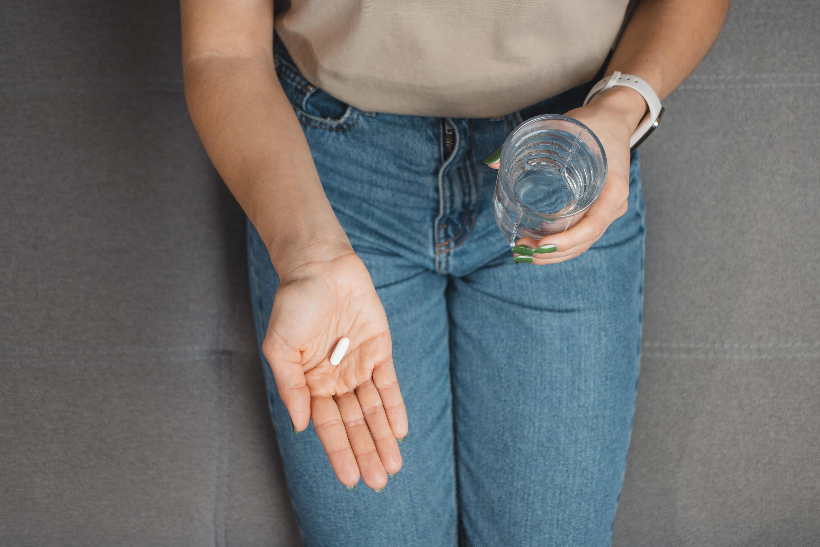 Personne prenant un antibiotique oral pour traiter la surinfection des lésions d’eczéma