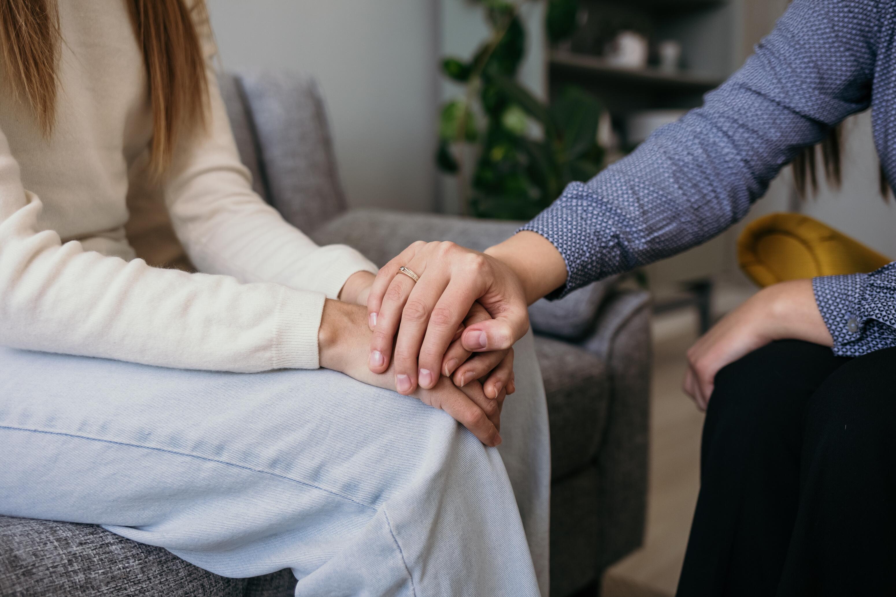 Personne qui soutient une autre personne en lui tenant les mains